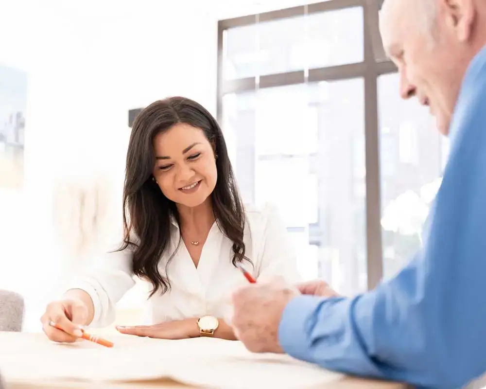 Oppenhome Immobilien - Karina Oppenländer geht bei einem entspannten Gespräch mit einem Kunden die Ergebnisse einer Immobilienbewertung durch.